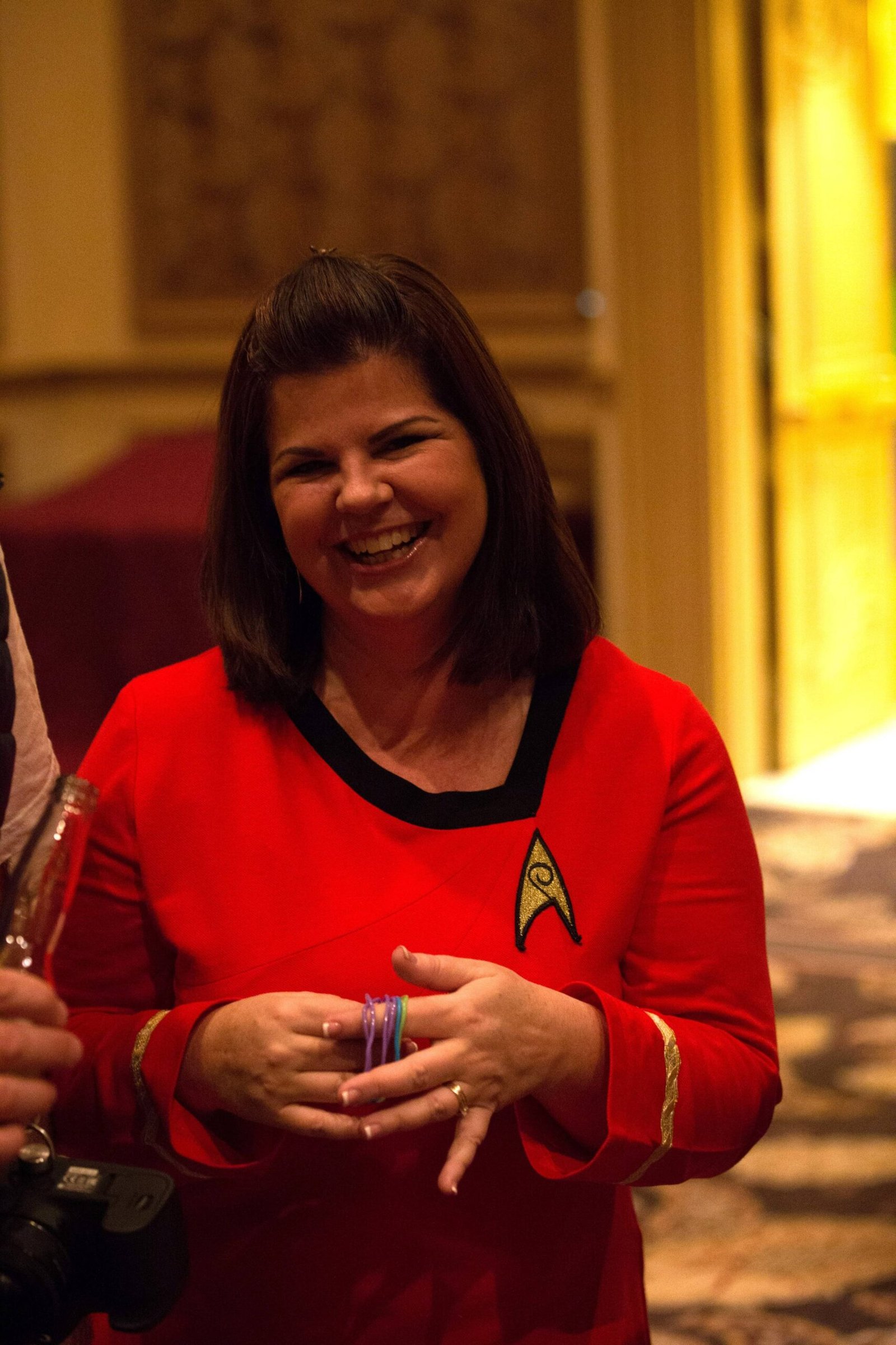 Jeannie Ruesch laughing in a red Star Trek uniform at an event